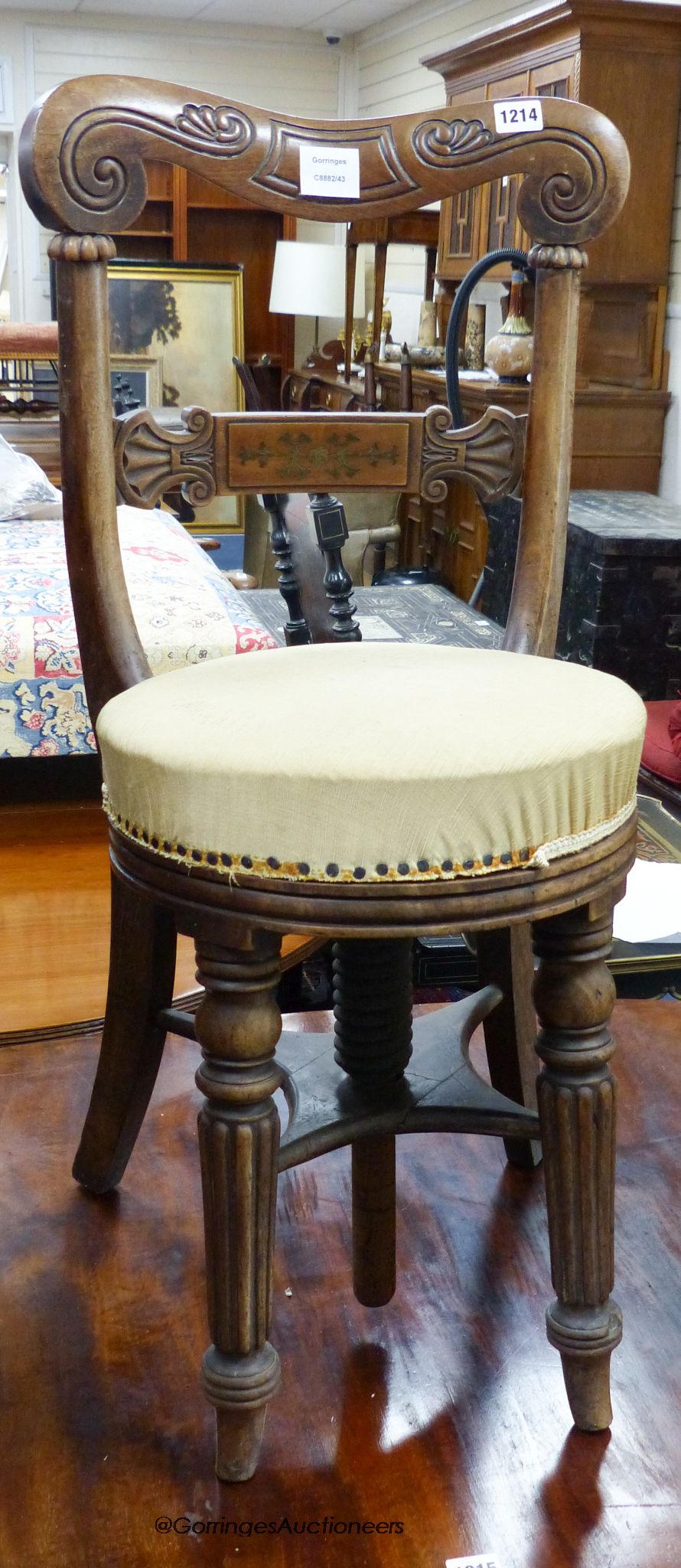 A regency brass inlaid mahogany music stool.